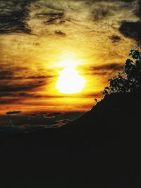 Scenic view of silhouette mountains against orange sky