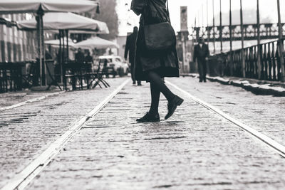 Rear view of woman walking on zebra crossing