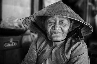 Close-up portrait of woman wearing asian style conical hat