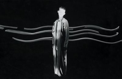 Midsection of woman standing against black background