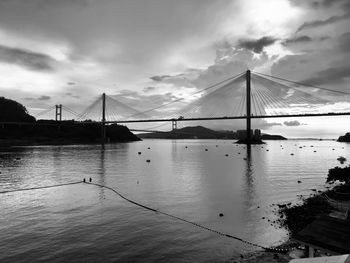 Tong kau bridge suspension bridge over sea against cloudy sky
