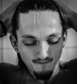 Close-up of young man taking bath at home