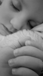 Close-up of baby hand on bed