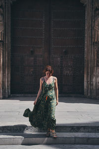 Full length of woman against brick wall