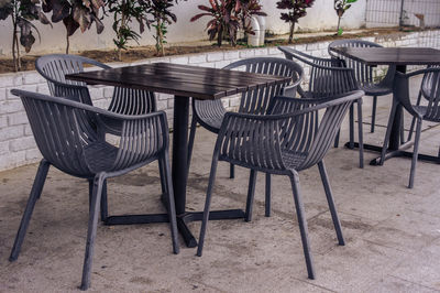 Empty chairs and table at sidewalk cafe