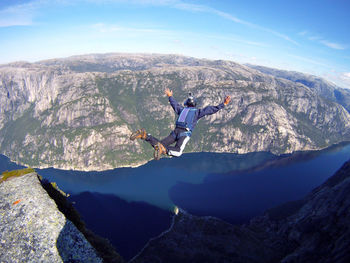 Man with arms outstretched against mountain range