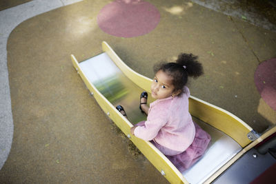 Portrait of girl having fun on slide in playground