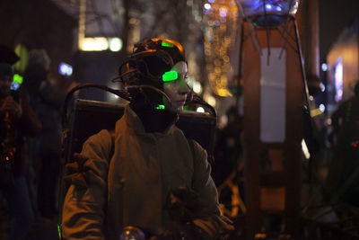 People walking on illuminated street at night