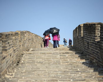 Tourist moving up on great wall of china against sky