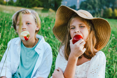 Siblings sitting on field