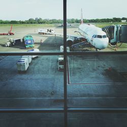 Airplane on airport runway against sky