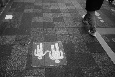 Low section of man standing on tiled floor