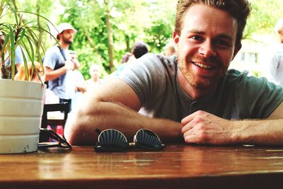 Portrait of a smiling young man sitting on table