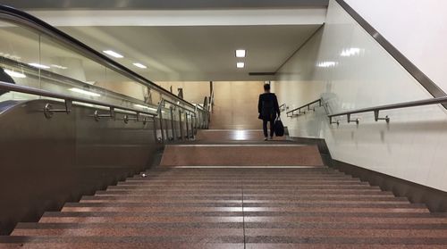 Rear view of woman walking on stairs