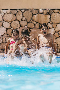 Children splashing water at the edge of the pool