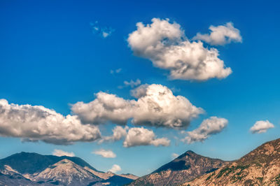 Low angle view of snowcapped mountains against cloudy sky