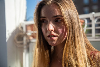 Close-up of young woman with blond hair looking away