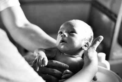 Close-up of hands holding newborn baby in hospital