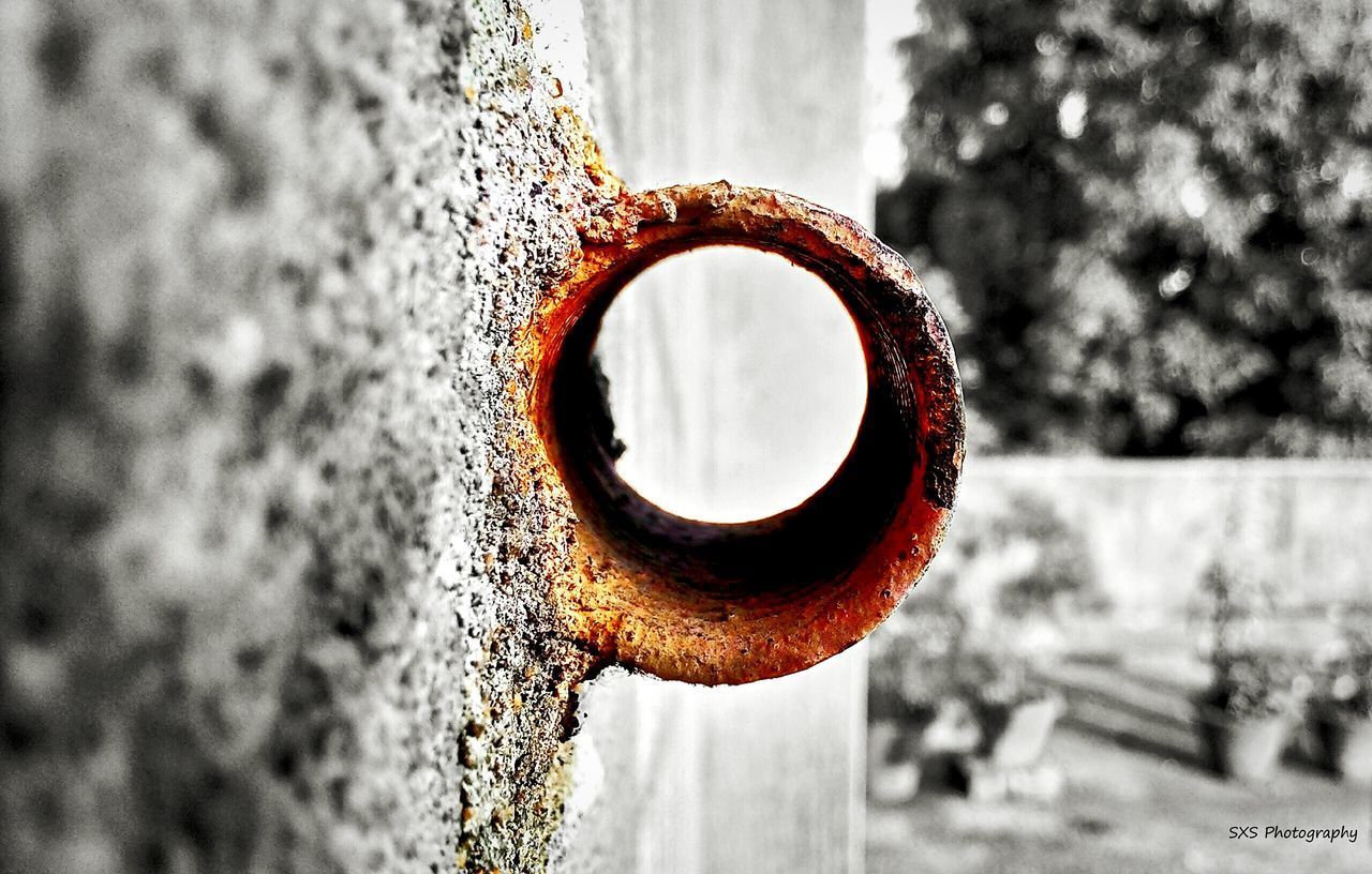 focus on foreground, close-up, circle, metal, protection, selective focus, metallic, pattern, day, hanging, wood - material, safety, rusty, no people, outdoors, design, fence, shape, hole