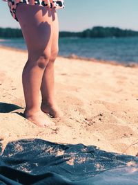 Low section of man standing on beach