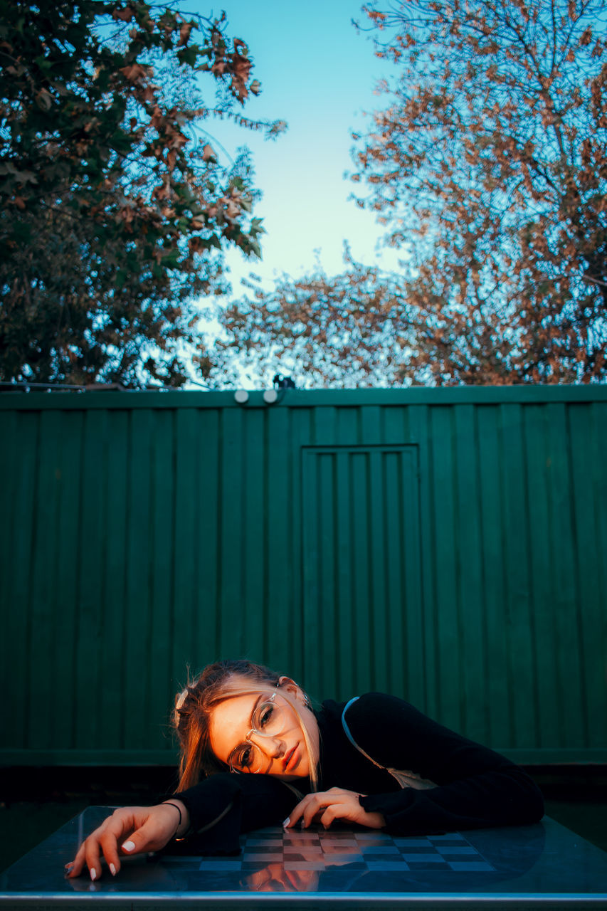 real people, one person, lifestyles, tree, leisure activity, young adult, plant, portrait, young women, day, nature, front view, women, headshot, looking, blue, females, outdoors, hairstyle, teenager