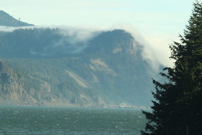 Scenic view of sea and mountains against sky