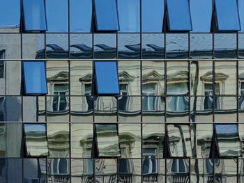 Buildings reflected in another glass building