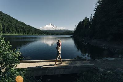 A father carries his daughter on his shoulders at trillium lake, or.
