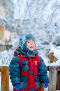 Boy on the street during a snowfall. winter portrait of a boy. happy child in the snow.