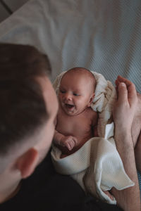 High angle view of baby boy lying on bed at home