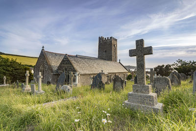 Tombstones at cemetery against sky