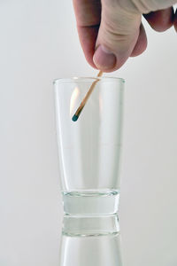 Midsection of person holding glass against white background