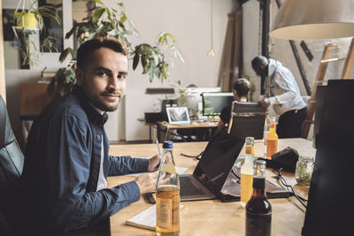 Portrait of entrepreneur working on laptop at workplace