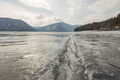 View of beautiful drawings on ice from cracks on the surface of lake teletskoye in winter, russia