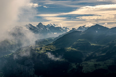 Scenic view of mountains against cloudy sky