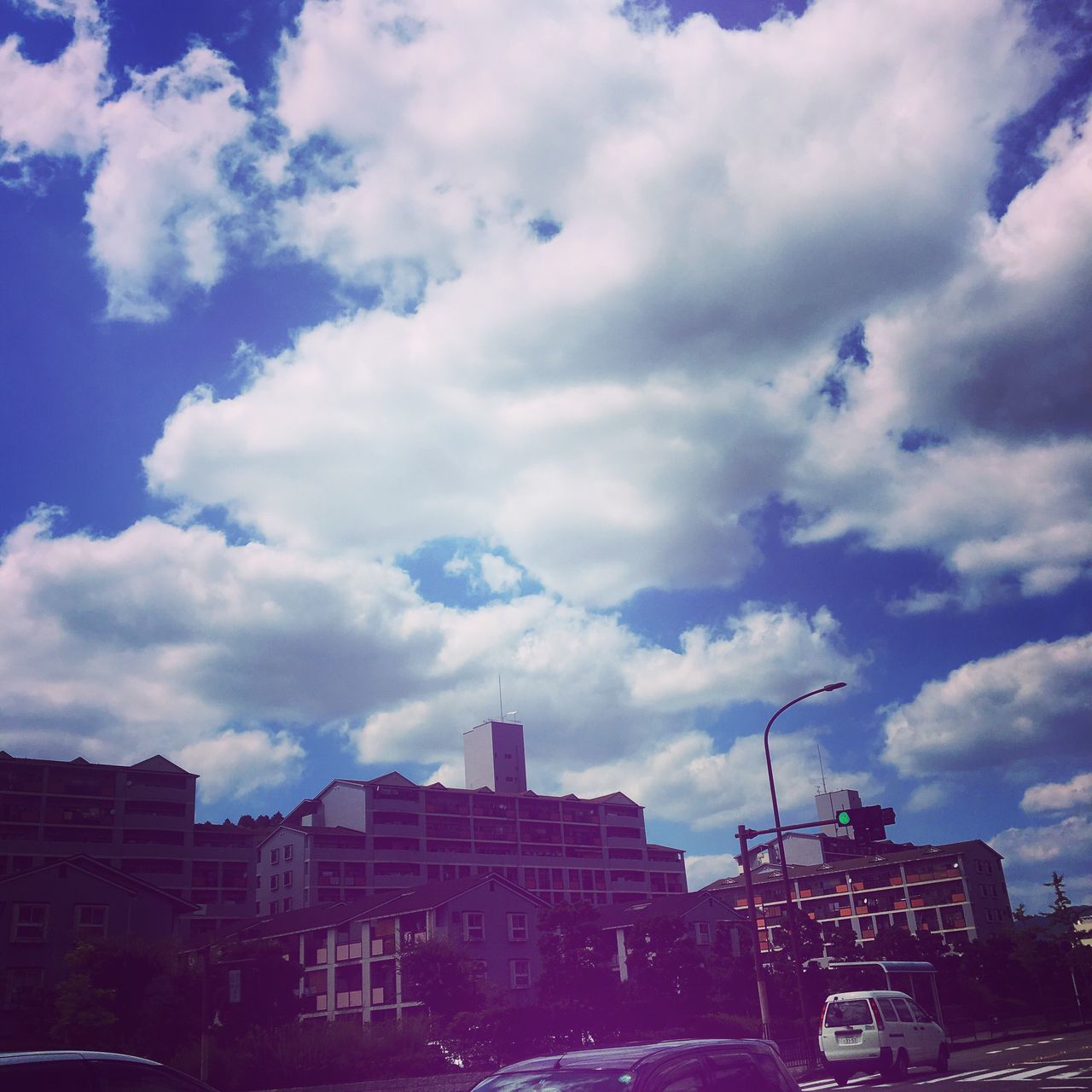 building exterior, architecture, built structure, sky, city, cloud - sky, cloudy, residential building, cloud, city life, building, cityscape, outdoors, residential district, city street, no people, day, weather, overcast, development, blue, nature