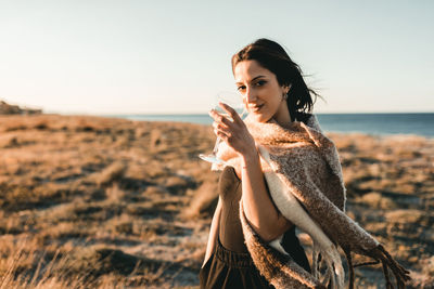 Portrait of young woman drinking outdoors