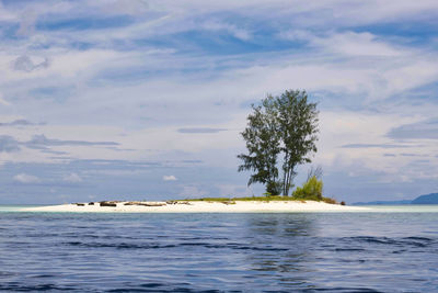 Scenic view of desert atoll in the middle of the sea against sky