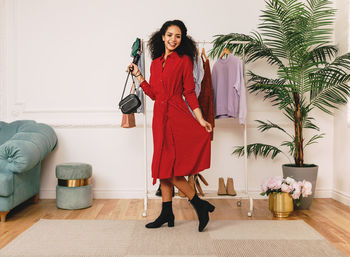 Portrait of smiling young woman standing on floor at home