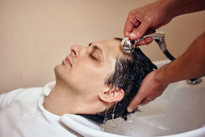 Close-up of man washing hair