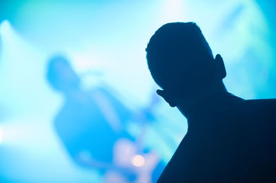 Rear view of man standing at music concert