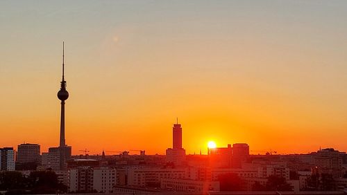 Buildings in city against sky during sunset