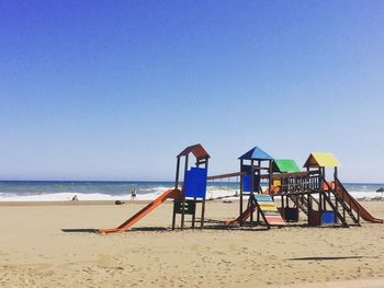 Lifeguard hut on beach against clear blue sky