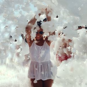 Digital composite image of young woman standing against white wall