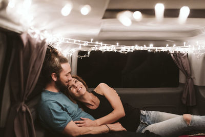 Young couple sitting in illuminated room