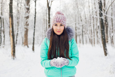 Portrait of young woman standing on snow