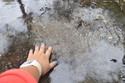 Low section of woman walking in water