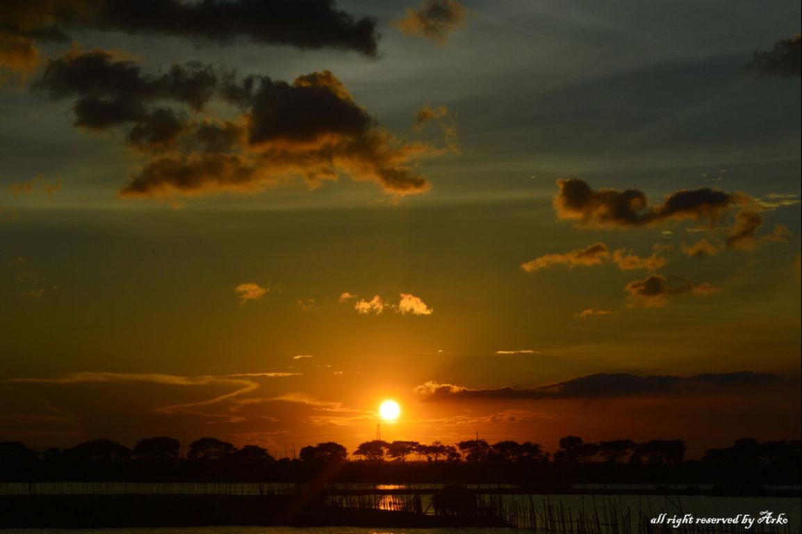 sunset, silhouette, sun, sky, scenics, orange color, tranquil scene, beauty in nature, tranquility, cloud - sky, idyllic, nature, sunlight, landscape, cloud, sunbeam, outdoors, dramatic sky, no people, water