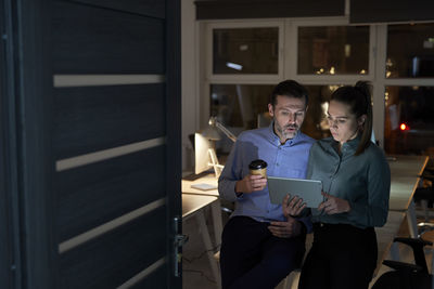 Smiling business people working late in office