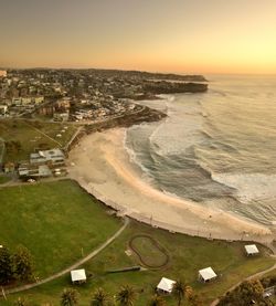 High angle view of sea and buildings against sky during sunset